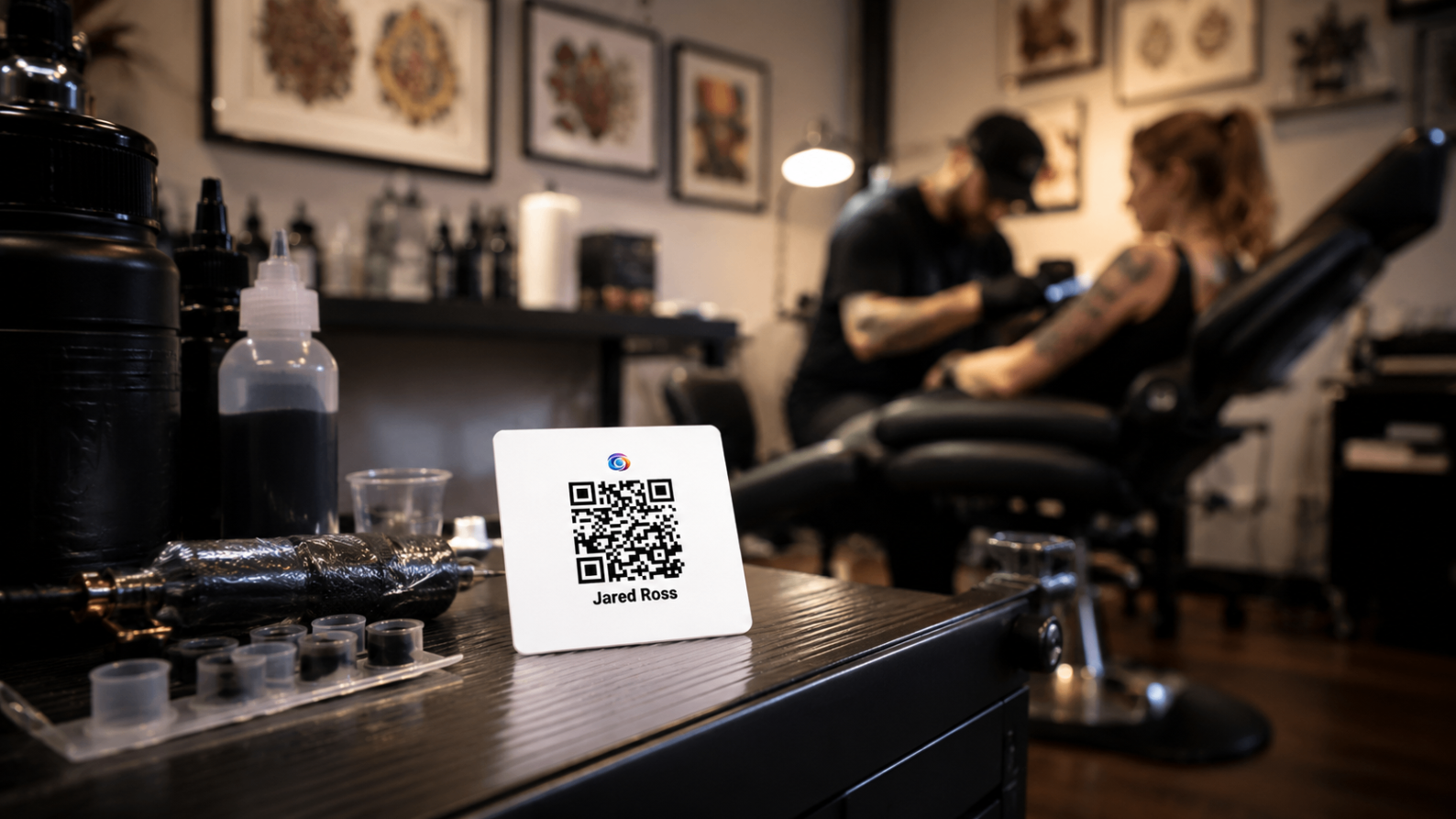 Tattoo studio with an EZTipr QR display card visible during a client session.